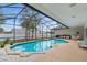 Screened-in pool area featuring a uniquely shaped pool and outdoor kitchen at 6229 Indian Meadow St, Orlando, FL 32819