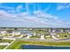 A bright aerial shot showcases beautiful homes situated alongside a serene lake, enhanced by clear, blue skies at 64 Citrine Loop, Kissimmee, FL 34758