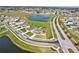 A scenic aerial perspective, highlighting a community's attractive houses adjacent to a tranquil lake and curving streets at 64 Citrine Loop, Kissimmee, FL 34758