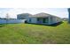 View of the backyard featuring a well-manicured lawn and a covered patio at 64 Citrine Loop, Kissimmee, FL 34758