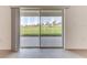 Sliding glass door leads to backyard view of green field and distant trees at 64 Citrine Loop, Kissimmee, FL 34758