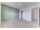 Serene bedroom with neutral carpeting, light green accent wall, closet, and doorway to an attached bathroom at 64 Citrine Loop, Kissimmee, FL 34758