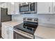 Kitchen features stainless steel range, microwave, and white cabinets at 64 Citrine Loop, Kissimmee, FL 34758