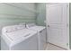 Well-equipped laundry room features modern washer, dryer, and overhead storage shelving at 64 Citrine Loop, Kissimmee, FL 34758