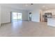 Bright living room featuring tile floors, sliding glass doors to the backyard, and an open floor plan to the kitchen at 64 Citrine Loop, Kissimmee, FL 34758