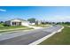 Street view featuring suburban home exteriors with lush green lawns, and a lake in the distance at 64 Citrine Loop, Kissimmee, FL 34758