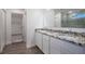 Bathroom featuring double vanity, granite countertop, wood floors, and a glass shower enclosure at 6627 Lullaby Way, Mascotte, FL 34753