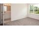 Bedroom featuring neutral carpet, a large window, and an ensuite bath and vanity at 6627 Lullaby Way, Mascotte, FL 34753