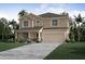 Two-story home featuring a two-car garage, landscaped front yard, and mixed siding at 6627 Lullaby Way, Mascotte, FL 34753