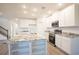 Modern kitchen featuring white cabinets, granite countertops, stainless steel appliances, and an island at 6627 Lullaby Way, Mascotte, FL 34753