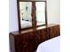 Close up of a wooden dresser with a stylish mirror and storage at 6910 Se 111Th Pl, Belleview, FL 34420