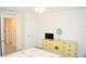 Bright bedroom featuring a light-colored dresser with ample storage, a ceiling fan, and an adjacent hallway at 6910 Se 111Th Pl, Belleview, FL 34420