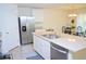 Well-lit kitchen features a stainless steel refrigerator and island with double sinks at 6910 Se 111Th Pl, Belleview, FL 34420