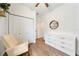 Bright bedroom featuring hardwood floors, a closet, a white dresser, and a comfortable rocking chair at 704 Hyperion Dr, Debary, FL 32713