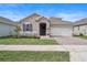 Charming single-story home with a well-maintained lawn, stone accents, and a two-car garage at 704 Hyperion Dr, Debary, FL 32713