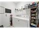 Efficient laundry room with a washer, dryer, shelving, and chalkboard, optimizing functionality and organization at 704 Hyperion Dr, Debary, FL 32713