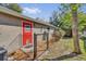 Exterior shot of home, showcasing the fenced in backyard and red door at 7448 Grand Ct, Winter Park, FL 32792