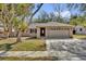 Charming single-story home featuring a two-car garage and well-maintained lawn at 7448 Grand Ct, Winter Park, FL 32792