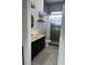 Stylish bathroom featuring a vanity with black cabinetry, a tiled shower, and decorative accents at 8744 Currituck Sound Ln, Orlando, FL 32829