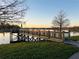 Community pier extending into the lake with green grass on the shores at 8744 Currituck Sound Ln, Orlando, FL 32829