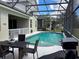 The screened in pool is surrounded by a patio, with a dining table, grill, and plenty of space for outdoor enjoyment at 8744 Currituck Sound Ln, Orlando, FL 32829