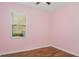 Bedroom featuring laminate flooring, a window, and soft pink walls at 981 Galway Blvd, Apopka, FL 32703