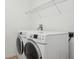 Laundry room with white walls and a washer and dryer, with a wire rack for storage above at 981 Galway Blvd, Apopka, FL 32703