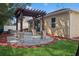 Backyard featuring a paved patio with a wooden pergola supported by stone columns and an attached house at 981 Galway Blvd, Apopka, FL 32703