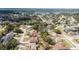 Scenic aerial view of a residential neighborhood featuring a home with a brown roof near a serene lake at 986 Sweetbrier Dr, Deltona, FL 32725