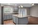 Open kitchen with a central island, stainless steel appliances, and access to outdoor spaces at 1010 Corbin Ct, Oviedo, FL 32765