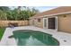 Backyard featuring a kidney-shaped swimming pool, concrete patio, and exterior door entry at 1010 Corbin Ct, Oviedo, FL 32765