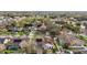 An aerial view shows a home with solar panels, a screened pool, lush landscaping, and a nice neighborhood at 1061 New Castle Ln, Oviedo, FL 32765