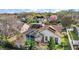 An aerial view shows a lovely home with a screened pool, solar panels, brick patio, and well-manicured landscaping at 1061 New Castle Ln, Oviedo, FL 32765