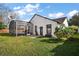 The backyard features a screened pool enclosure and a brick patio, surrounded by lush green grass and landscaping at 1061 New Castle Ln, Oviedo, FL 32765