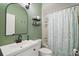 Bathroom features a stylish black-framed mirror, floating shelves, and a shower with a patterned curtain at 1061 New Castle Ln, Oviedo, FL 32765