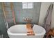 Elegant soaking tub with modern fixtures and a wooden ladder shelf, creating a spa-like bathroom retreat at 1061 New Castle Ln, Oviedo, FL 32765