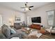 Bright living room with comfortable seating, decorative rug, and large windows offering natural light at 1061 New Castle Ln, Oviedo, FL 32765