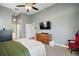 Relaxing main bedroom with neutral colors, TV, a ceiling fan, and a door to the main bathroom at 1061 New Castle Ln, Oviedo, FL 32765