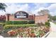 Welcoming entrance sign to The Manors North/Westridge with colorful flowerbeds at 109 Grosvenor Loop, Davenport, FL 33897