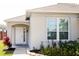 Inviting front entrance with a white door, sidelight, and manicured landscaping at 109 Grosvenor Loop, Davenport, FL 33897