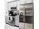 Kitchen featuring stainless steel appliances, gray cabinets, and tiled floor at 109 Grosvenor Loop, Davenport, FL 33897