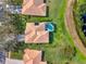 Aerial view of the property showing roofline, screened pool and proximity to pond at 11327 Ledgement Ln, Windermere, FL 34786