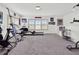 Spacious exercise room, featuring carpet flooring, multiple windows, and various workout machines at 11327 Ledgement Ln, Windermere, FL 34786