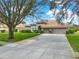 Stunning single-story home with a tile roof, well-kept lawn, mature trees, and a spacious driveway at 11327 Ledgement Ln, Windermere, FL 34786