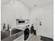 Well-lit laundry room with modern washer and dryer, white cabinets and stainless steel sink at 11327 Ledgement Ln, Windermere, FL 34786