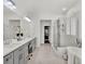 Luxurious main bathroom featuring dual sinks, a glass shower, and a soaking tub with plantation shutters at 11327 Ledgement Ln, Windermere, FL 34786