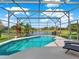 A private screened-in pool that overlooks a beautiful lake with manicured landscaping at 11327 Ledgement Ln, Windermere, FL 34786