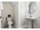 Powder room featuring a pedestal sink, oval mirror, and decorative plant at 11381 Satire St, Orlando, FL 32832