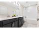 Bathroom featuring double sinks with modern faucets and vanity with black cabinets and white countertops at 11381 Satire St, Orlando, FL 32832