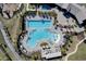 Aerial view of the community pool with ample seating and a splash pad surrounded by mature landscaping at 11381 Satire St, Orlando, FL 32832